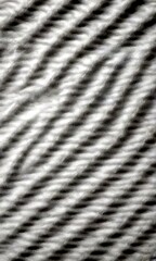 Fototapete - a close-up view textured surface, possibly a fabric or a woven material, with a repeating pattern of diagonal lines or stripes