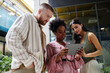 © Seventyfour - Medium shot of three business people from different ethnic backgrounds collaboratively using digital tablet looking at screen while working in modern office center