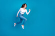 © deagreez - Full size photo of pretty teen girl running hurry black friday wear trendy white outfit isolated on blue color background