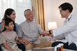 © Success Media - The doctor gives a health check to an Asian grandfather, daughter and grandson.