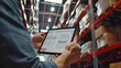 © Brynjar - A person using a tablet to manage inventory in a warehouse setting.