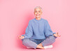 © deagreez - Full length photo of pretty retired female sit floor meditation wear trendy blue knitwear outfit isolated on pink color background
