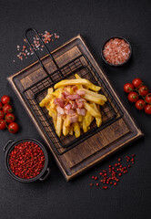 Crispy French fries with pieces of bacon, salt and spices