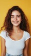 © BrandwayArt - Young woman with curly hair smiles against a vibrant yellow backdrop