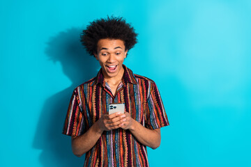 Sticker - Portrait of nice young man use phone empty space wear shirt isolated on turquoise color background