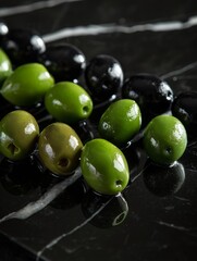 Green and black olives on a glossy black marble surface. Close-up of shiny olives arranged in a row.