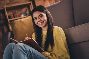 Wall Mural - Photo portrait of attractive teen woman sit floor sofa smile write diary dressed yellow outfit cozy day light home interior living room