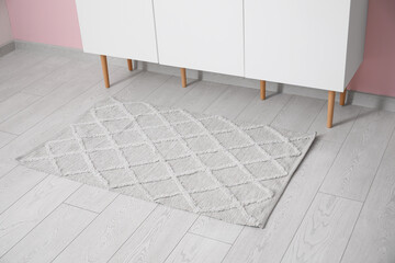 Stylish rug and white sideboard in living room, closeup