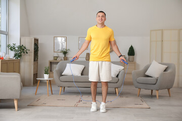 Sticker - Sporty young man jumping with rope at home