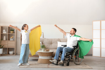 Poster - Little girl and her father in wheelchair with superhero capes playing at home