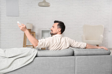 Poster - Young man turning on air conditioner at home