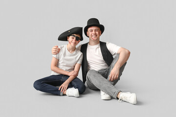 Poster - Father with his son dressed for Halloween sitting on light background