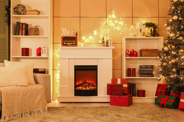 Canvas Print - Interior of cozy living room with fireplace, shelving units and Christmas tree decorated for holiday at night