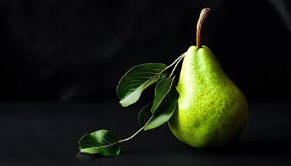 Vibrant green pear with lush leaves against a striking black backdrop