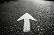 © nikolettamuhari - A simple white arrow on asphalt, representing the direction of progress or...