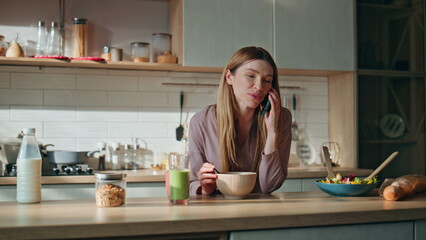 Wall Mural - Happy woman calling kitchen countertop. Happy girl talking smartphone at morning