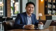 © YENI - Asian businessman working from cafe with laptop