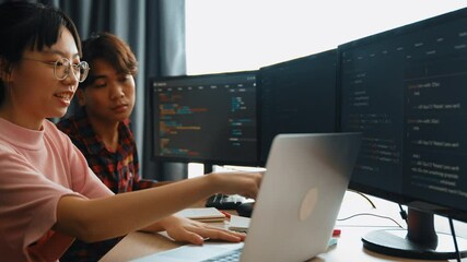Slow motion back end software developer engineer for computer programming working together on debugging writing computing code, solving complex algorithms display on monitor in office. Burgeoning