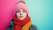 © Thipphaphone - Cheerful Young Woman Wearing Winter Hat and Scarf Against Colorful Background