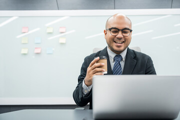 Young asian businessman working with laptop in the office. CEO Businessman analyzing statistics financial Meeting Conference Discussion various topic Corporate