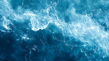 Aerial view of ocean water with white foam.