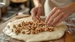 © Faxri - preparing a tasty baklava. Woman at wooden table chopping nuts for dough, close-up
