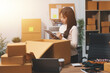 © Kansuda - Startup SME small business entrepreneur of freelance Asian woman wearing apron using laptop and box to receive and review orders online to prepare to pack sell to customers, online sme business ideas.