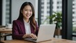 © YENI - Cheerful young asian businesswoman using laptop