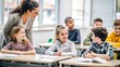 © Htet Wai Phyo - Happy diverse kids sitting at desk in classroom and talking with teacher, studying during lesson, woman explaining subject to pupils