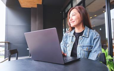 Wall Mural - portrait image of a young woman working on laptop computer in cafe