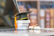 © William W. Potter - Graduate study abroad program to broaden learner's world view, e-learning concept : Graduation cap, foreign books on a laptop, depicts student attempting to study from a distance or learning from home