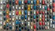 © Dina - An aerial view of a crowded parking lot with cars neatly lined up, demonstrating patterns and organization in public parking areas