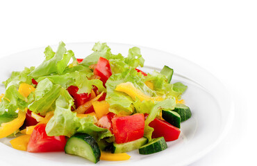 Fresh salad with lettuce, tomatoes, cucumbers and peppers on white plate