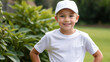 © QuoDesign - Little boy wearing white t-shirt and white baseball cap standing in the garden