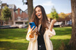 © zvkate - Portrait photo smiling young girl browsing internet with cellphone mobile phone wearing casual clothes shirt gesturing like winner. Brunette woman look happy, celebrating win, triumph, success, wow.