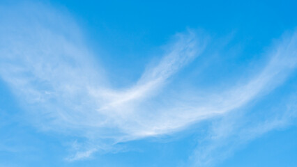 the sky is clear blue with fluffy white clouds, the sky is very bright, and the sun shines.