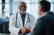 © Martí Rosselló - Smiling Doctor Shaking Hands with Patient During Consultation Happy doctor greeting a patient with a handshake during a consultation, symbolizing trust and professionalism in healthcare
