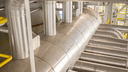 Industrial Piping System. Close-up view of an industrial piping system with multiple pipes and tubes arranged in a complex network, showcasing the intricate details of modern infrastructure.