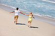 © Leffy/peopleimages.com - Couple, freedom and holding hands at beach for travel, bonding or tropical holiday with energy. Man, woman and running outdoor for fun trip, love and vacation with adventure, relax or date on weekend