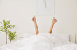 © Studio Romantic - Female person waking up in the morning lying in bed under cozy white blanket in bedroom, stretching arms and showing thumb up sign. Relaxed sleepy woman happy to start a new day in the morning.