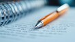 ©  Jovaduplex - An orange pen rests on a spiral notebook filled with writing, depicting the act of capturing thoughts or information, emphasizing the importance of documentation.