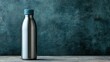 ©  Jovaduplex - A metallic water bottle with a teal cap standing on a wooden surface against a textured teal background, highlighting its modern and simple design.