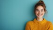 ©  Jovaduplex - A happy woman wearing a yellow sweater is smiling broadly, set against a calm blue background, emanating a sense of warmth, joy, and cheerful positivity.