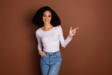 Poster - Portrait of nice young woman indicate finger empty space wear pullover isolated on brown color background