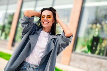 Sticker - Photo of shiny attractive lady dressed grey coat dark eyewear smiling enjoying good weather outdoors town street