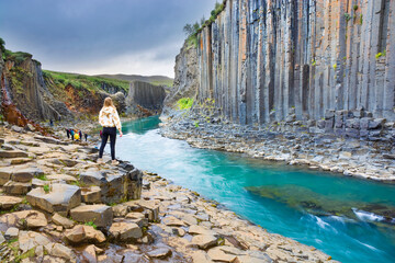 Wall Mural - Unrecognizable tourists at Stuðlagil Canyon known for its columnar basalt rock formations, Iceland