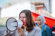 © Odua Images - female student holding megaphone while leading a rally on indonesian independence day