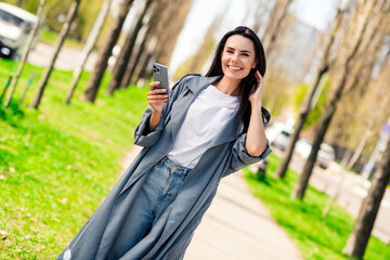 Sticker - Photo of shiny attractive lady dressed grey coat walking texting device enjoying good weather outdoors town street