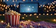 © Kamonwan - A cozy outdoor movie night featuring popcorn, a large screen, and twinkling lights, perfect for summer gatherings.
