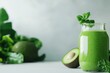 © auc - Fresh green smoothie with avocado and mint on a light background.